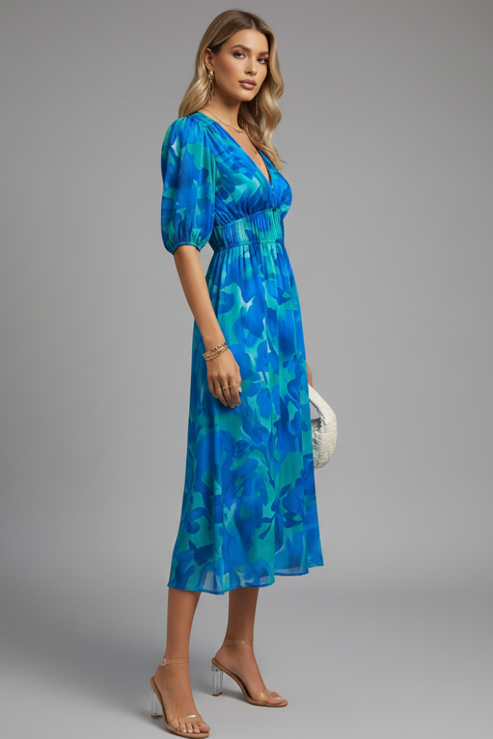 Woman posing front view in floral puff sleeve midi dress.
