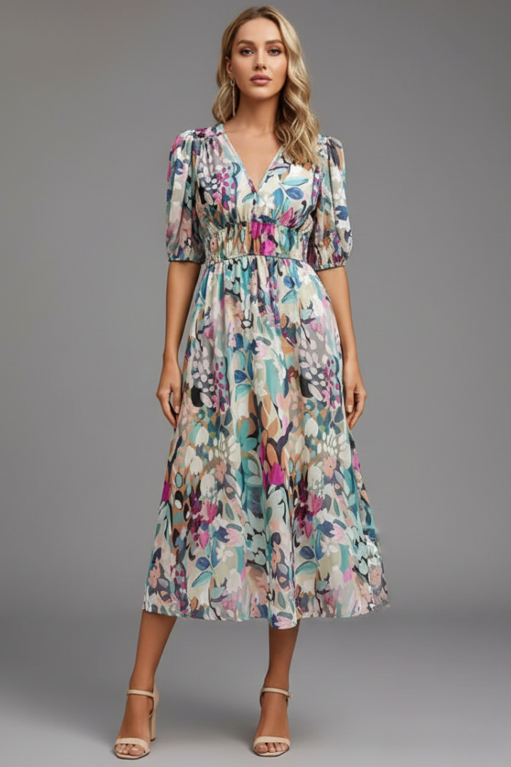 Woman in flowing midi dress with puff sleeves standing.