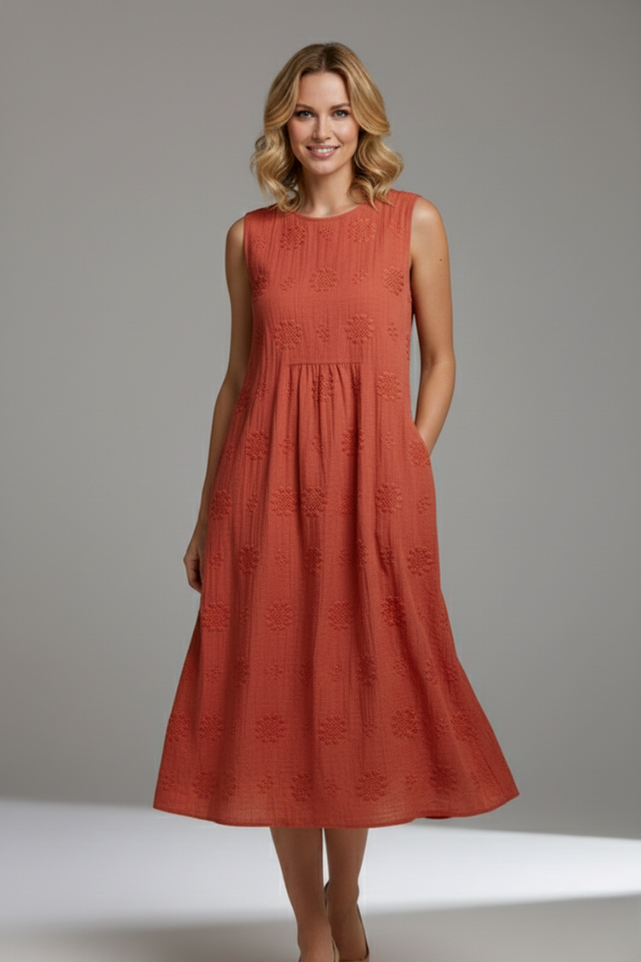 Woman modeling patterned midi dress from side angle indoors softly.