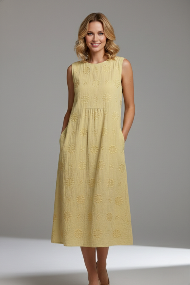 Woman wearing loose midi dress with circular textured pattern details.