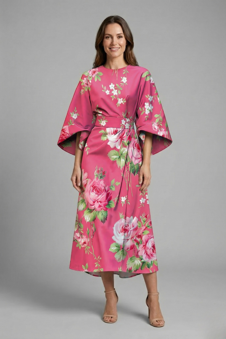 Female model wearing wide sleeve midi dress on gray backdrop.