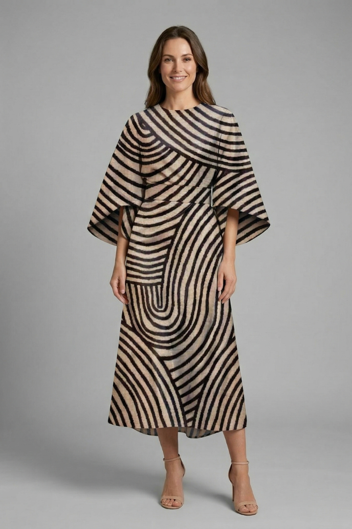 Woman wearing abstract linear print dress on plain gray background.
