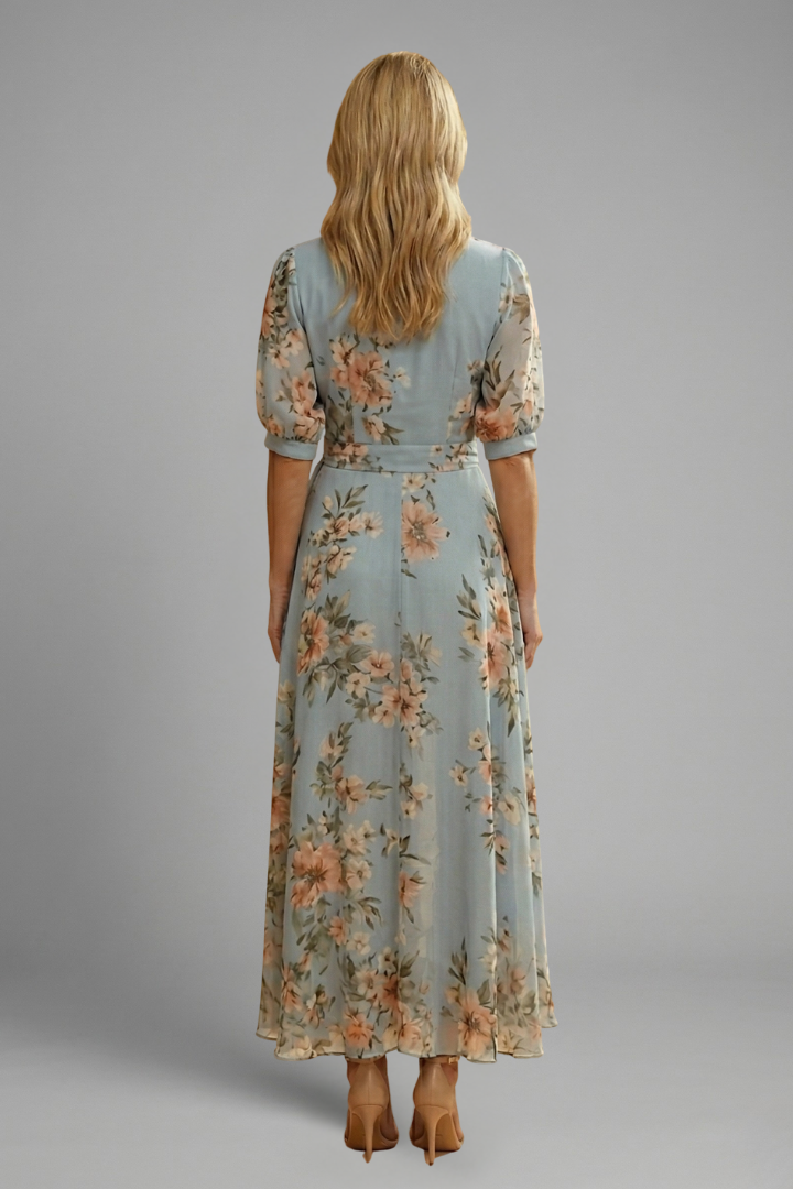 Woman posing in a below-knee patterned dress, back angle.