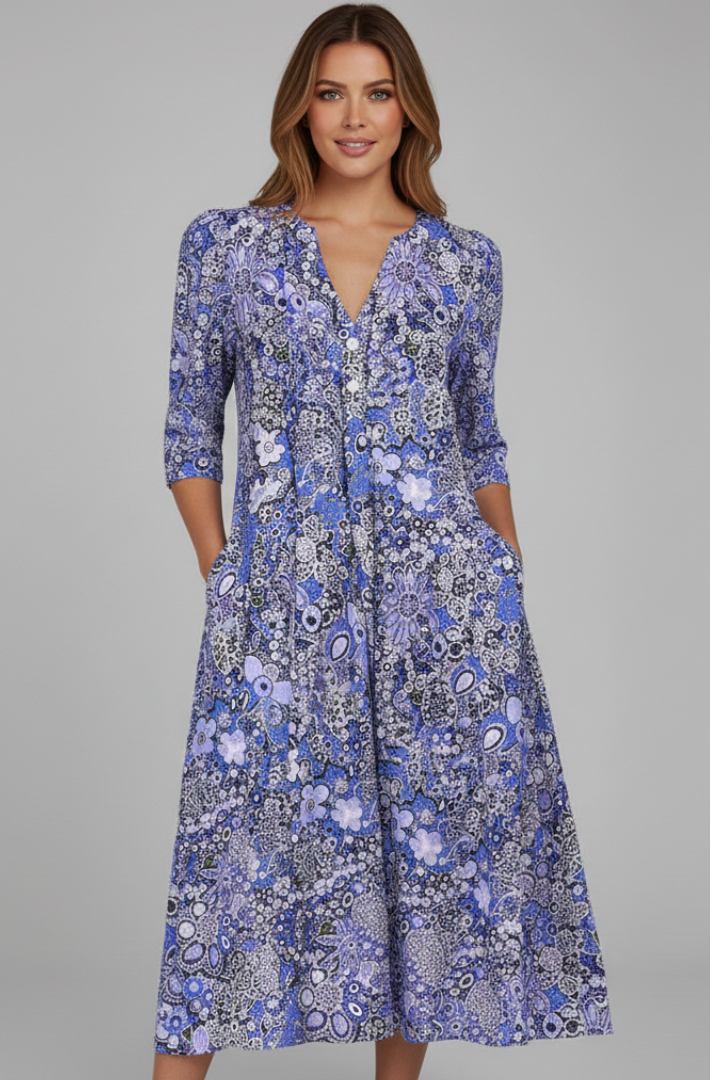 Woman wearing printed midi dress posing front view on gray background.