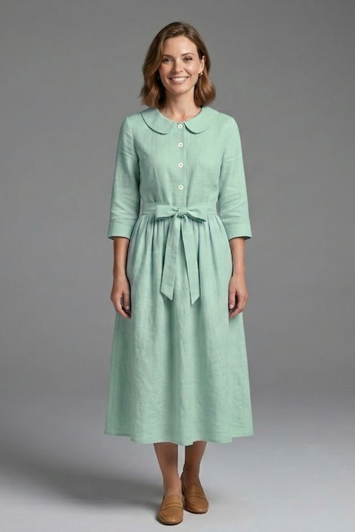 Female model showing V-neck dress detail on gray background.