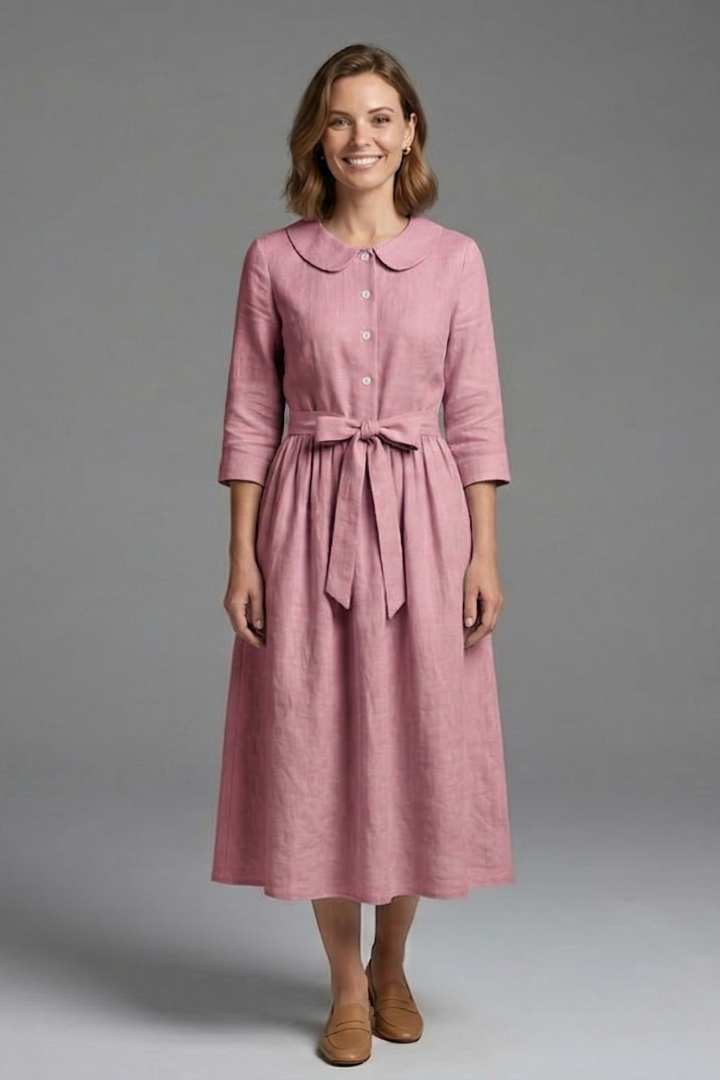 Woman wearing textured midi dress full length gray background shot.