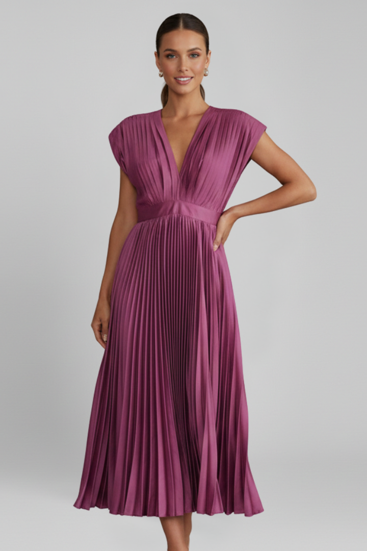 Full body front angle model wearing pleated dress in gray background