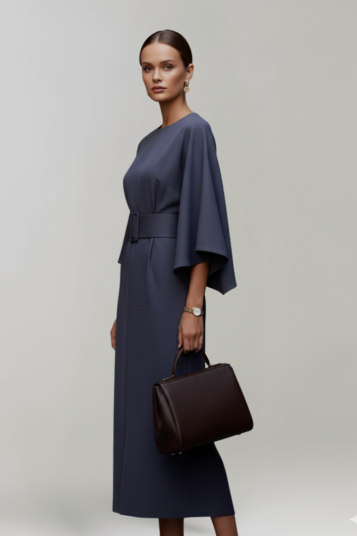 Female model in elbow sleeve dress with waist belt, gray background.