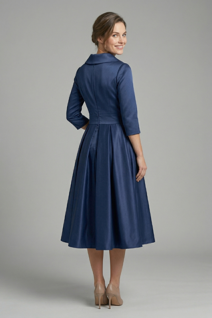 Female model in an elegant midi dress with a clean plain background.