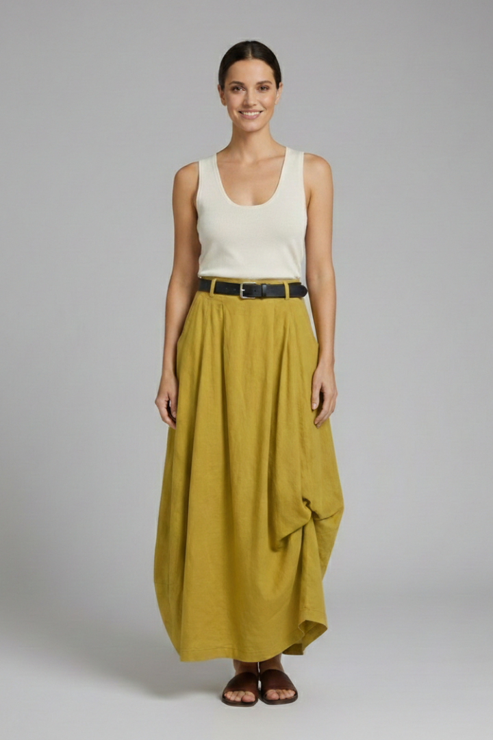 Model wearing textured yellow midi skirt on gray background