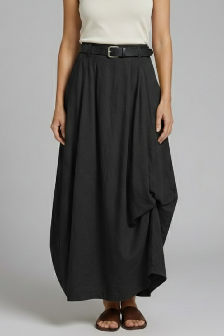 Model posing in A-line black skirt gray background