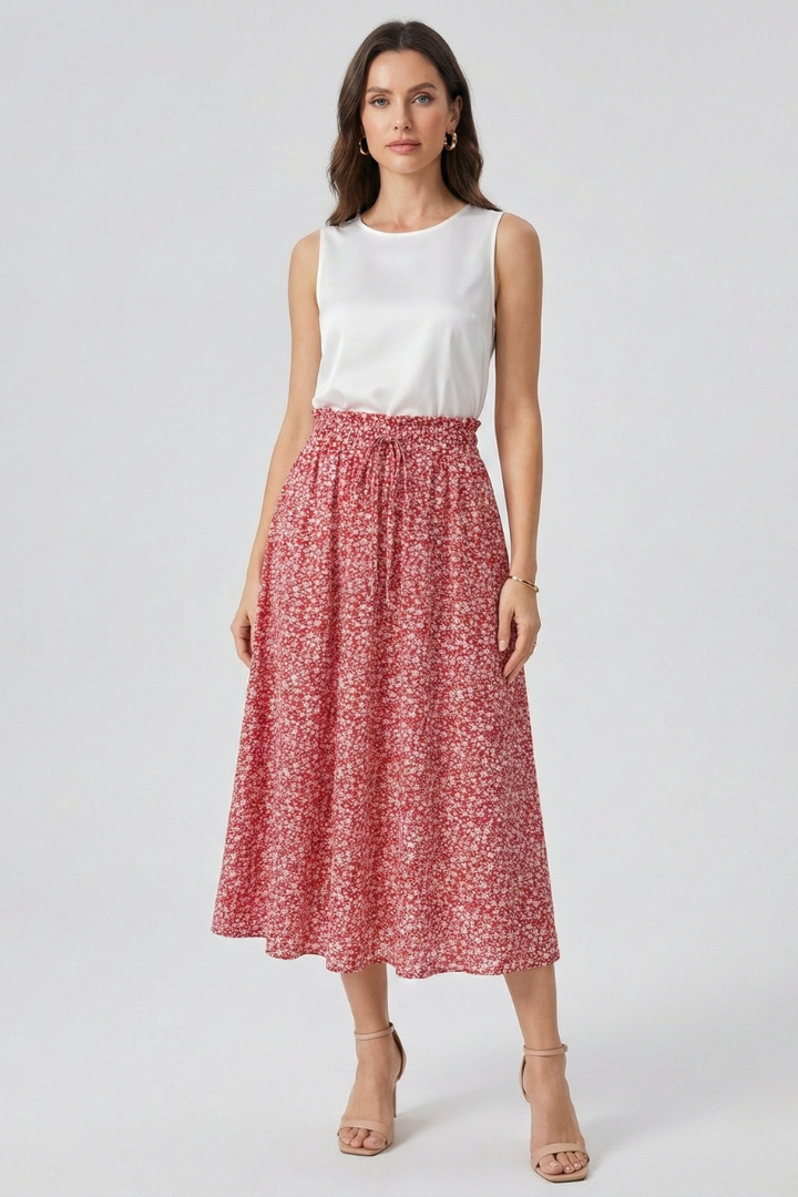 Full view of model wearing midi skirt with white top on white background