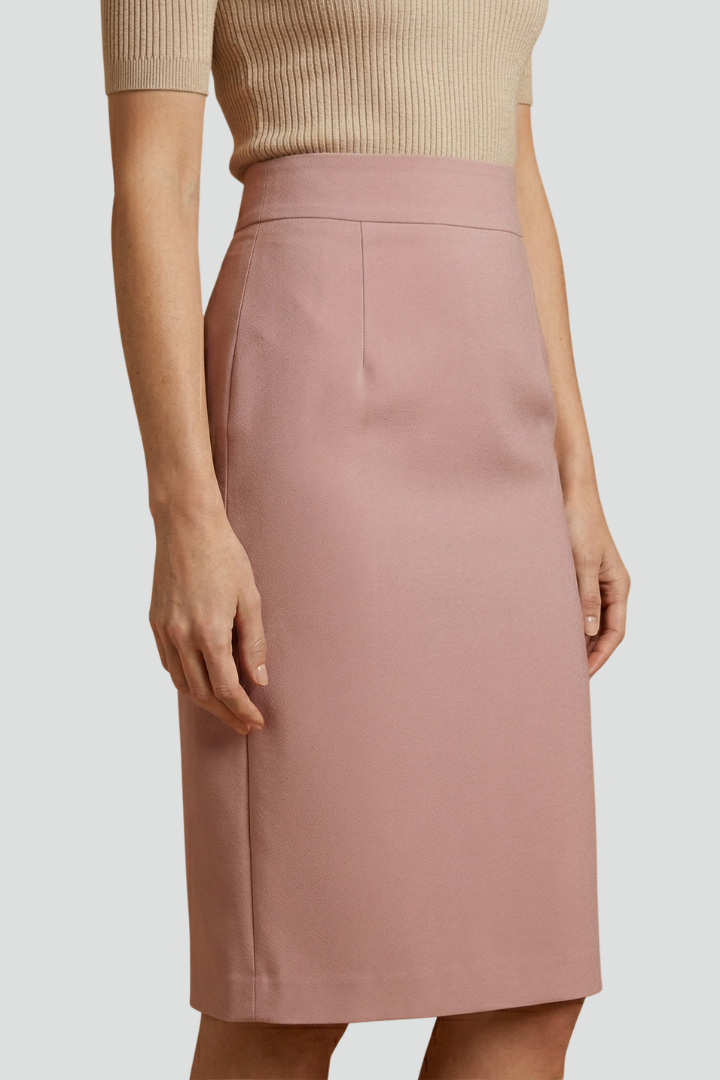 Female model wearing a sleek high rise midi skirt on a plain background.