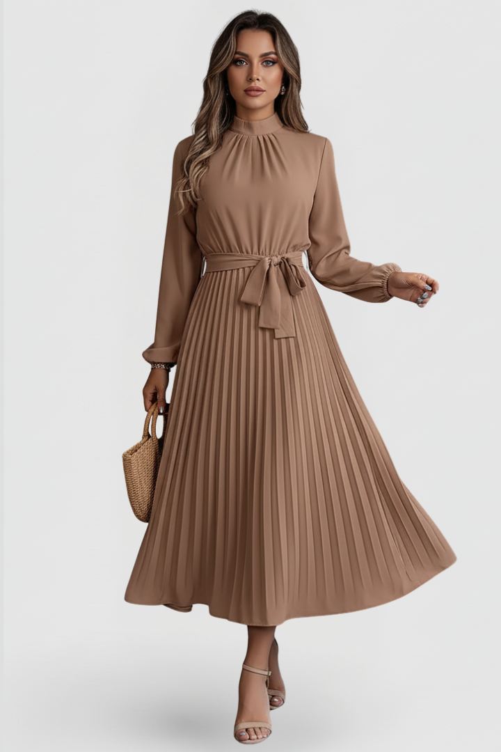 Woman posing in fitted cuff long dress, gray background.