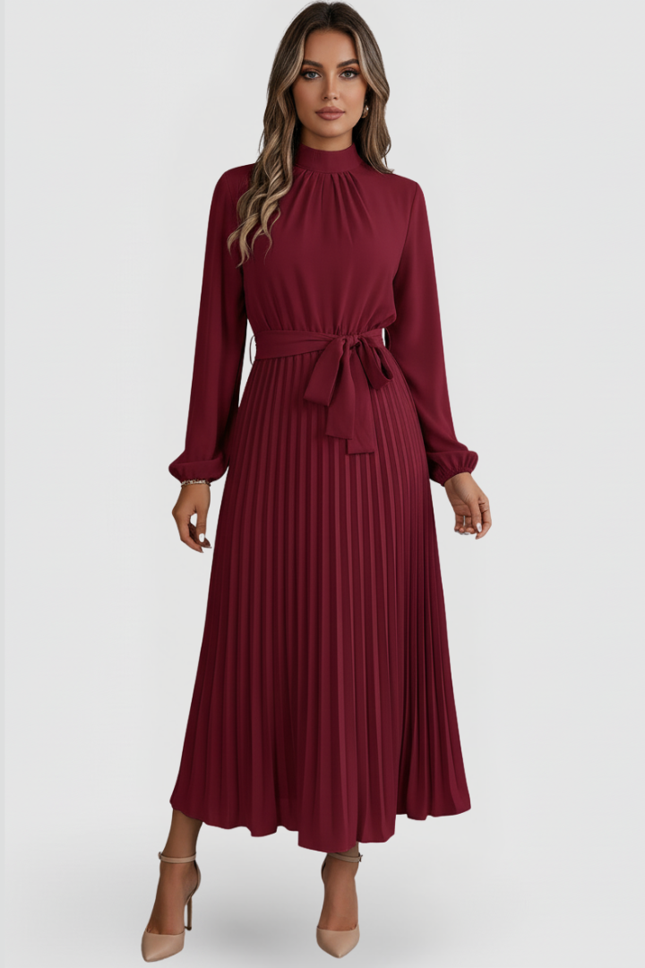 Female model posing in below calf pleated red dress, gray background.