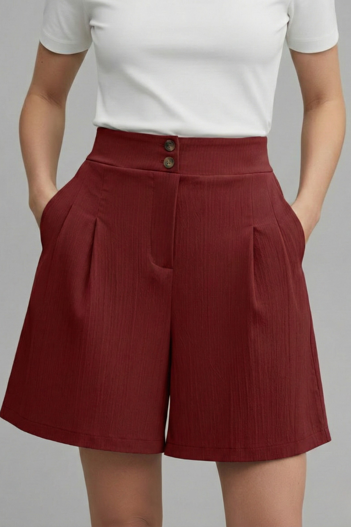 Model wearing wide leg knee length red shorts