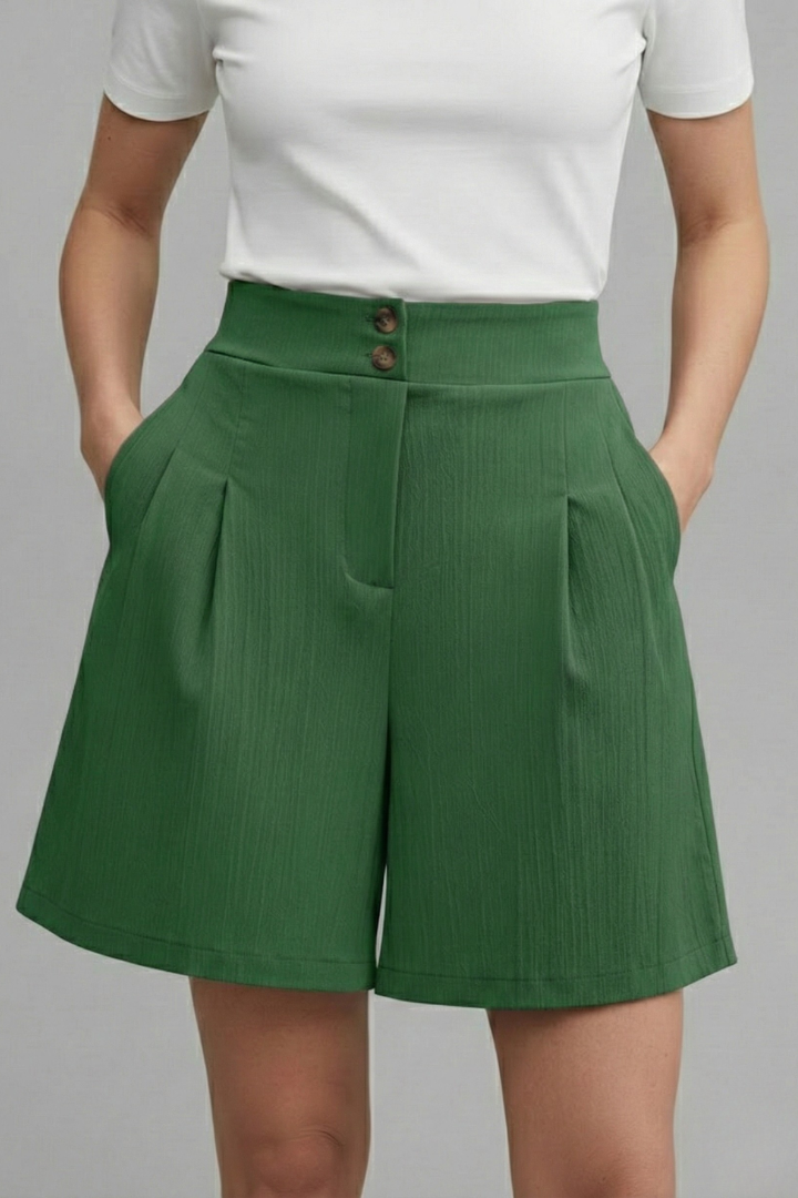 Front button detail on women’s green shorts gray backdrop