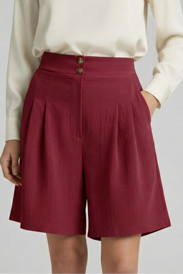 Woman in elegant flowy red shorts in standing pose pair with white top