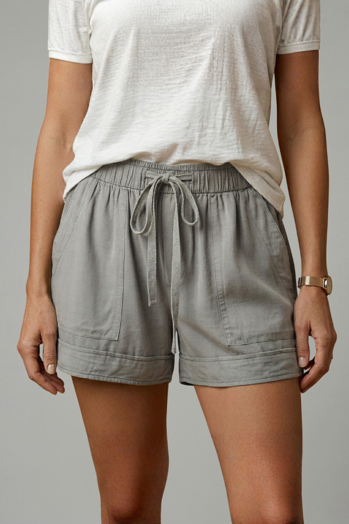 Model posing with relaxed leg gray shorts