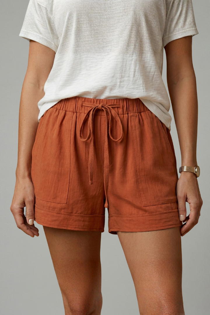 Model relaxed stance in red shorts