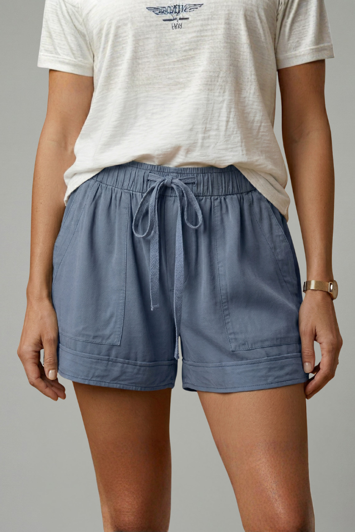 Model standing casually in loose blue shorts