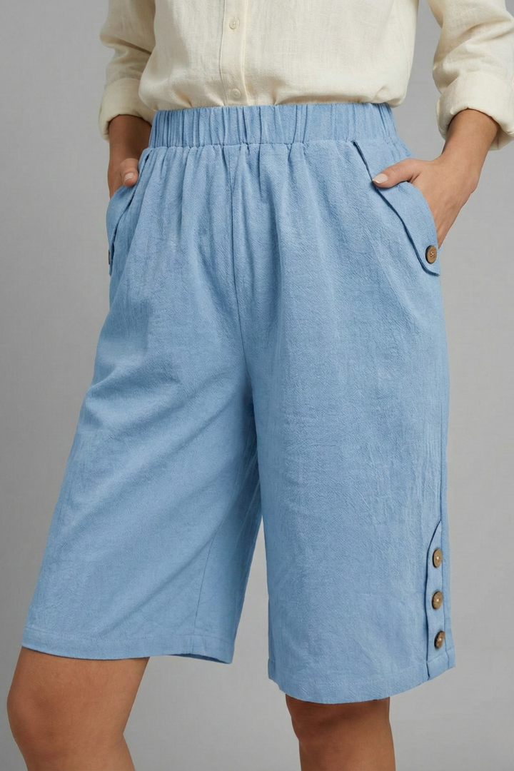 Female model wearing loose straight leg blue shorts