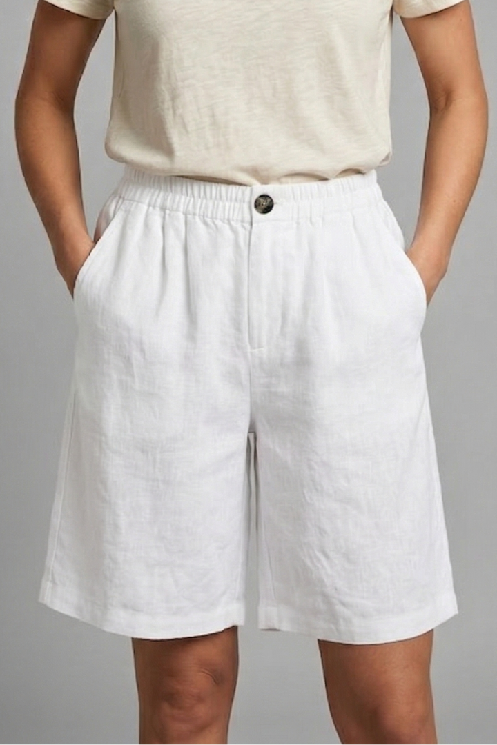 Mid-length loose shorts on female model, gray background
