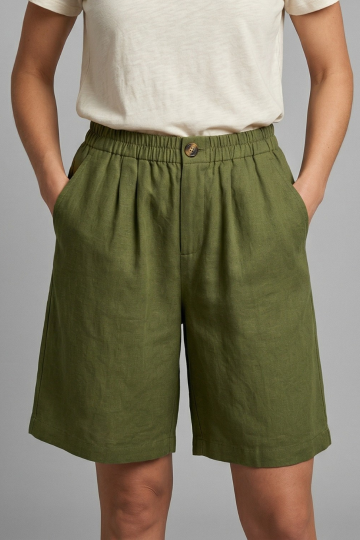 Model in mid-length shorts, plain gray background