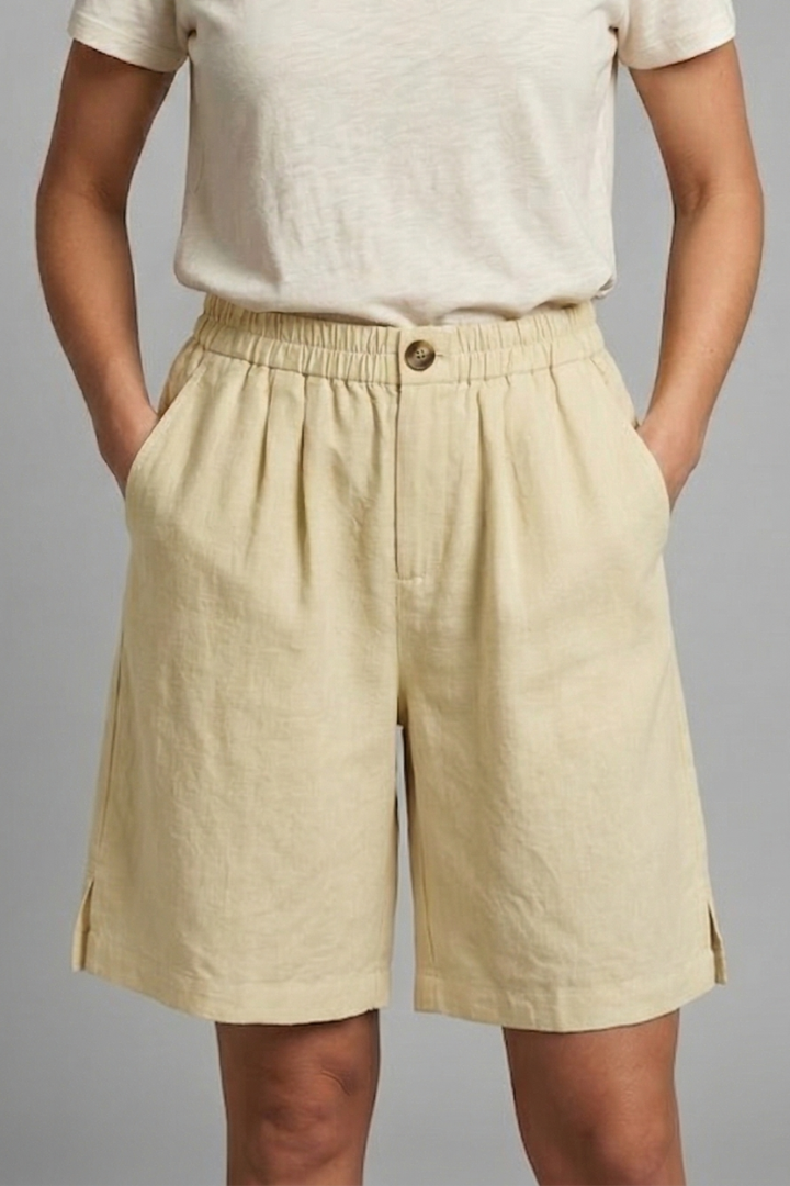 Female model in comfortable drawstring yellow shorts, front view