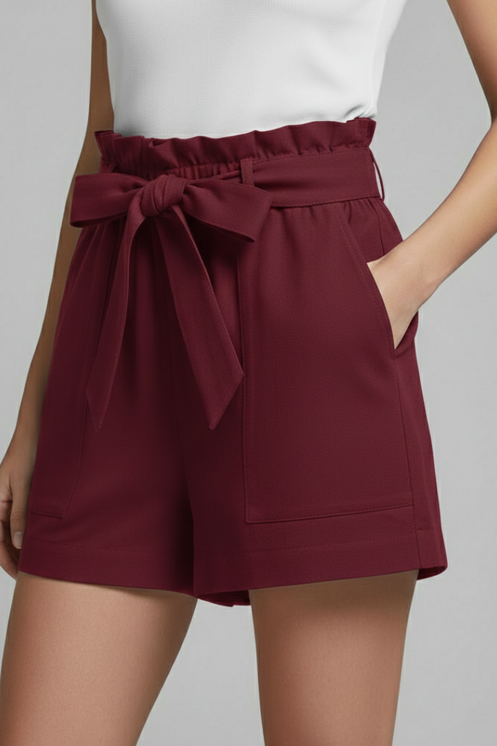Model standing still with relaxed red shorts in gray background