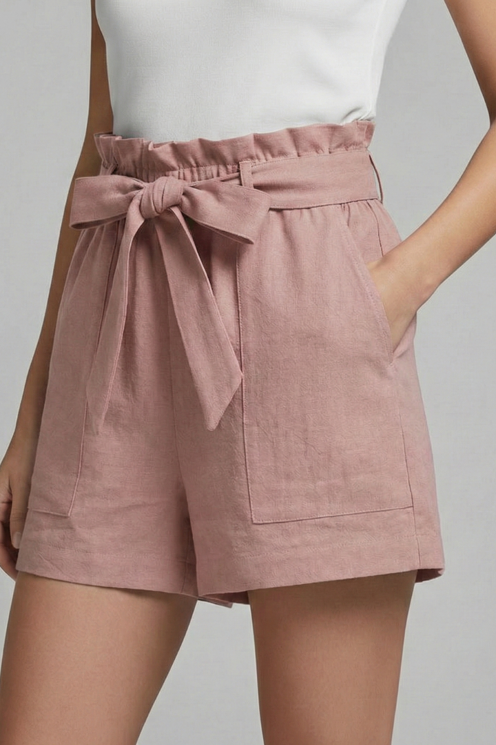 Female model front pose showing loose leg pink shorts on gray background