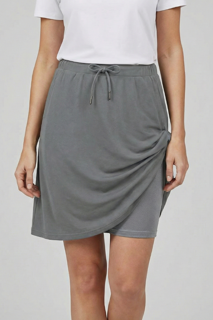 Woman angled front gray skirt in plain background