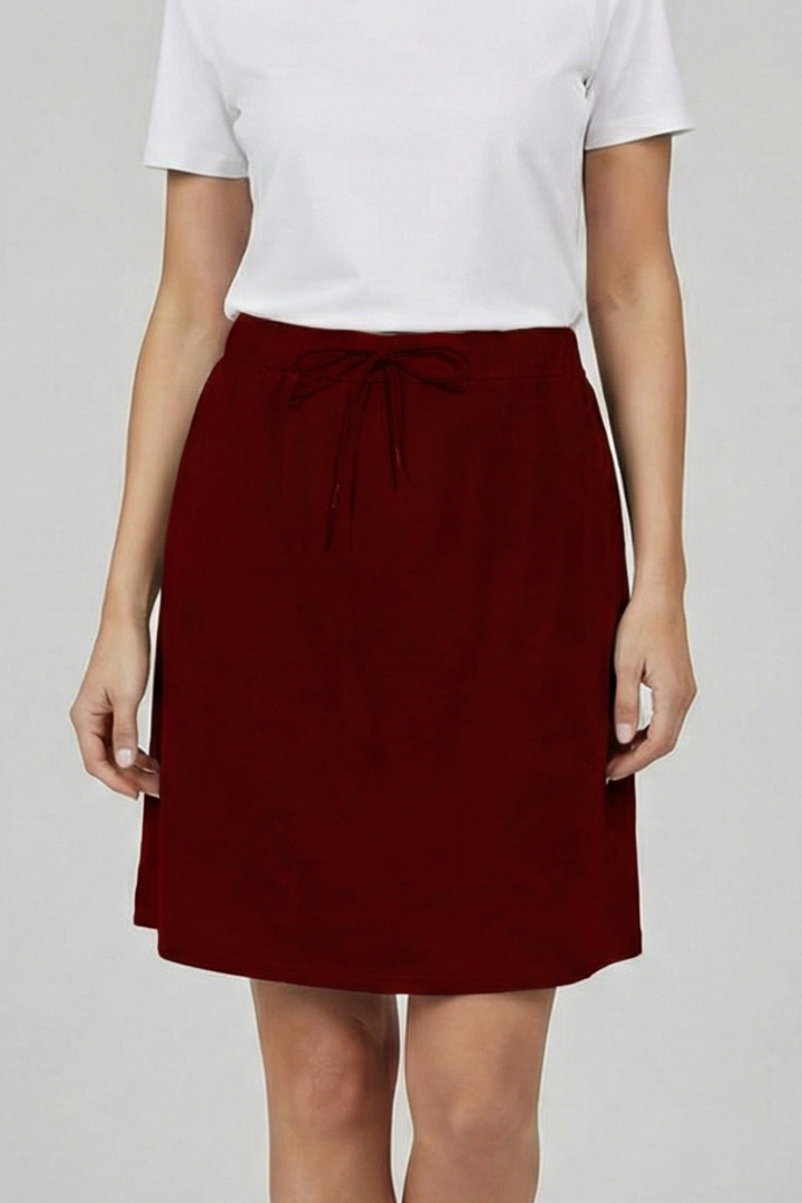 Woman full body white top red skirt on plain gray background