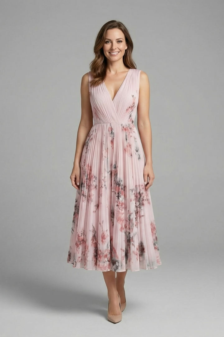 Model wearing printed pink pleated dress on gray background