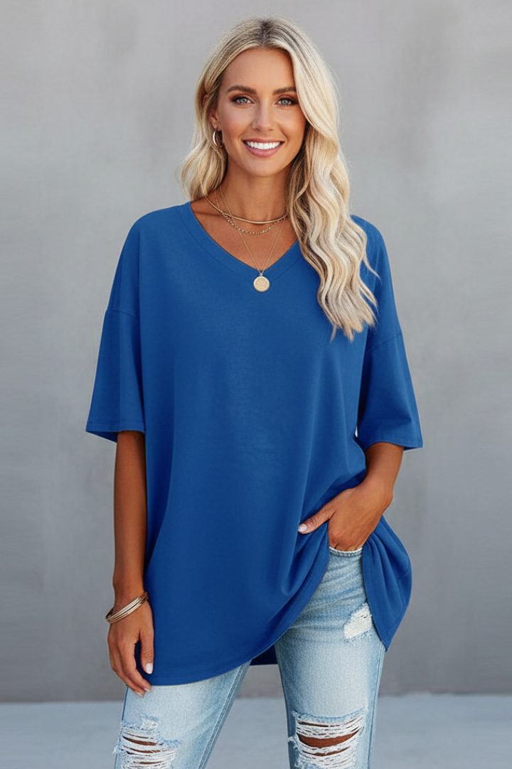 Woman smiling wearing blue tee front display on gray background