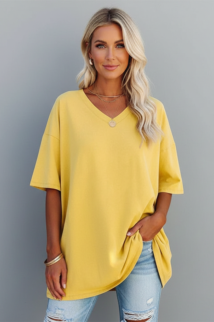 Front facing women’s yellow short sleeve top gray background