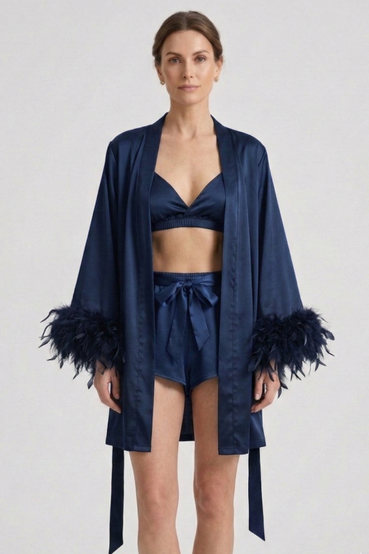 Woman wearing bralette and wrap shorts and with robe on plain gray background