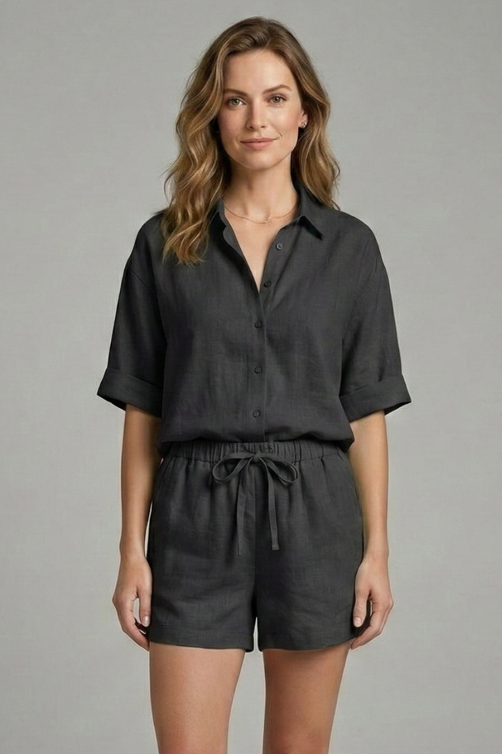 Woman wearing loose-fit two-piece black set, front angle, gray background.