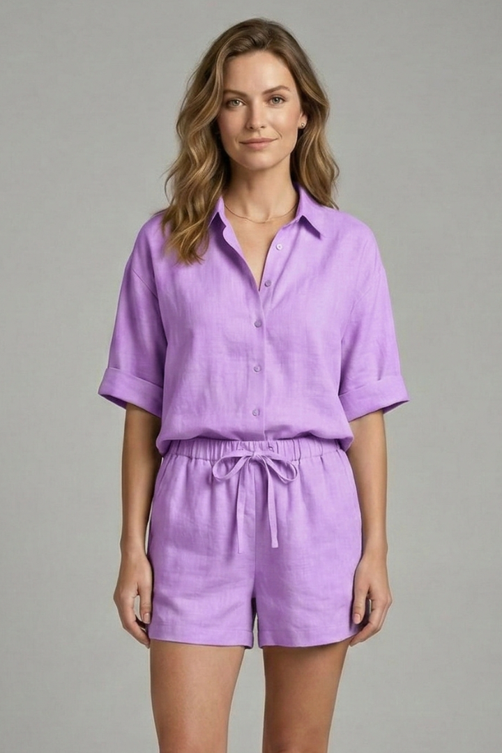 Woman posing naturally in summer purple two-piece outfit, plain gray background