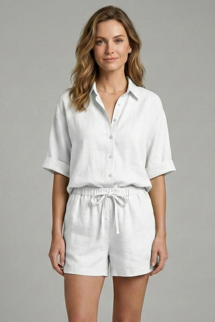 Woman in elbow-sleeve all white shirt and shorts set, plain gray background