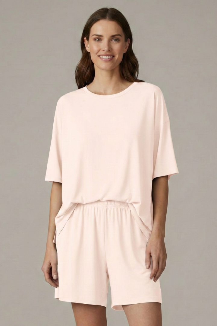 Female model angled pose loose white clothing set in gray background