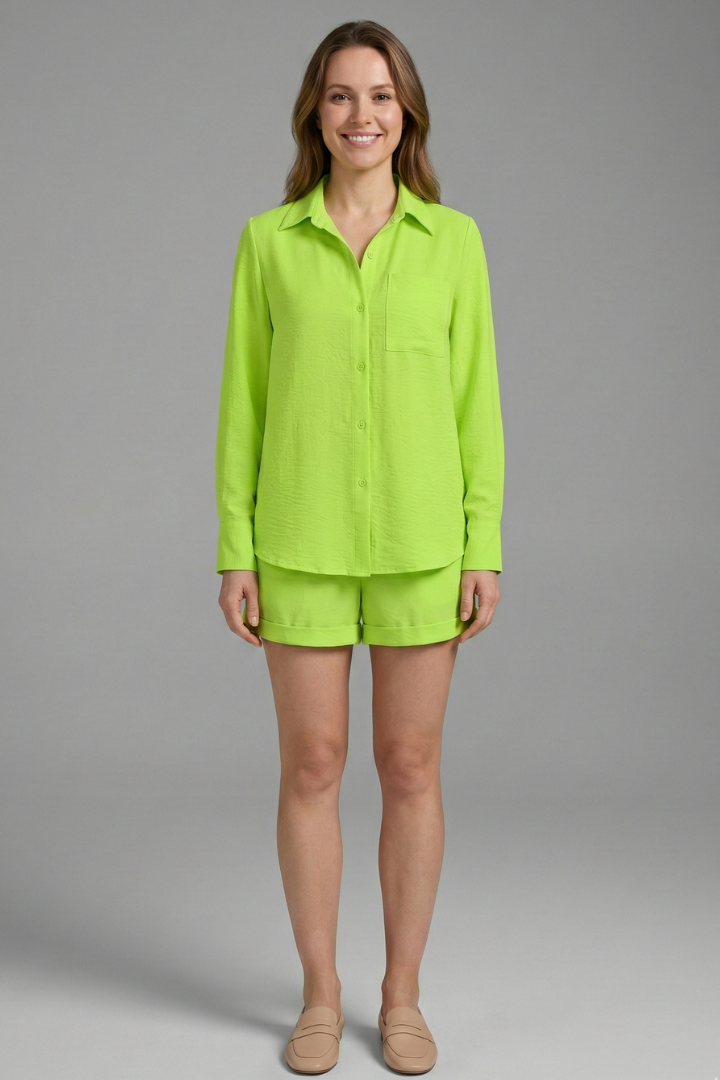Woman modeling green long sleeve top and shorts set on gray background