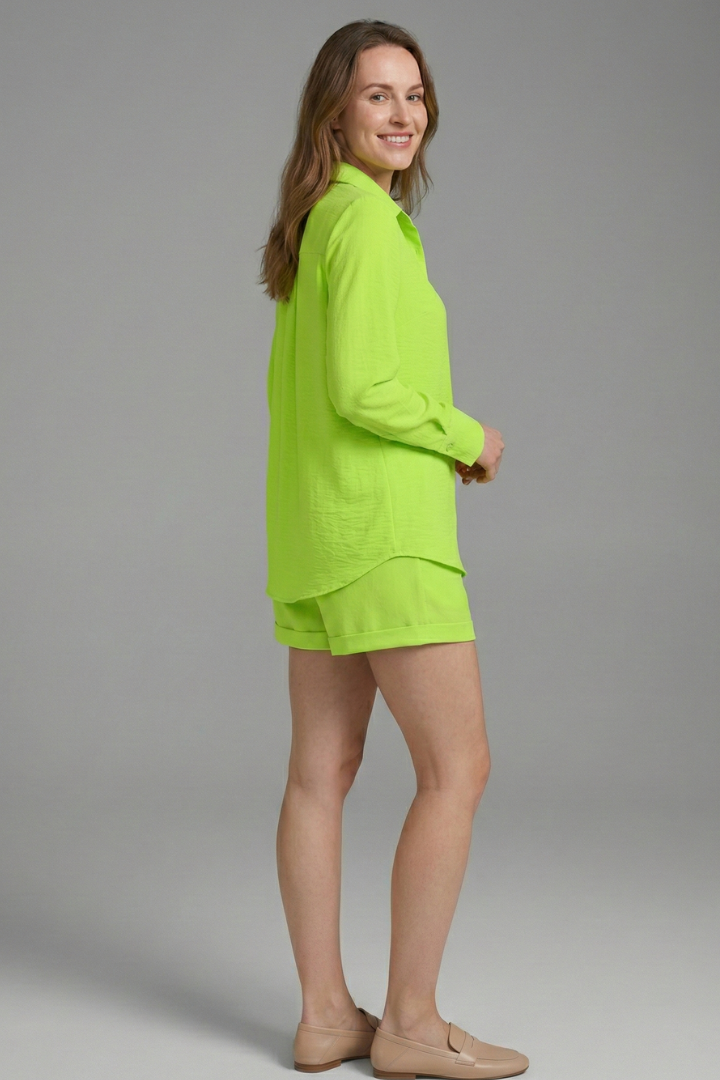 Female model wearing relaxed fit shirt and shorts gray background