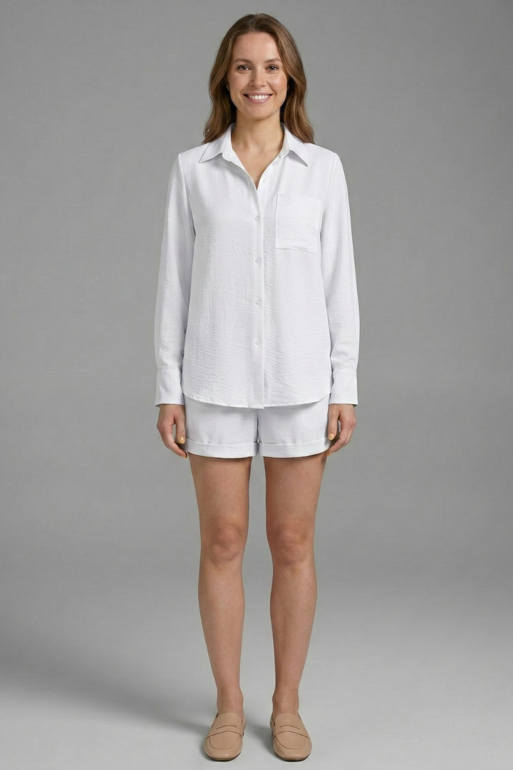 Woman in polished casual all white outfit set on plain gray background 