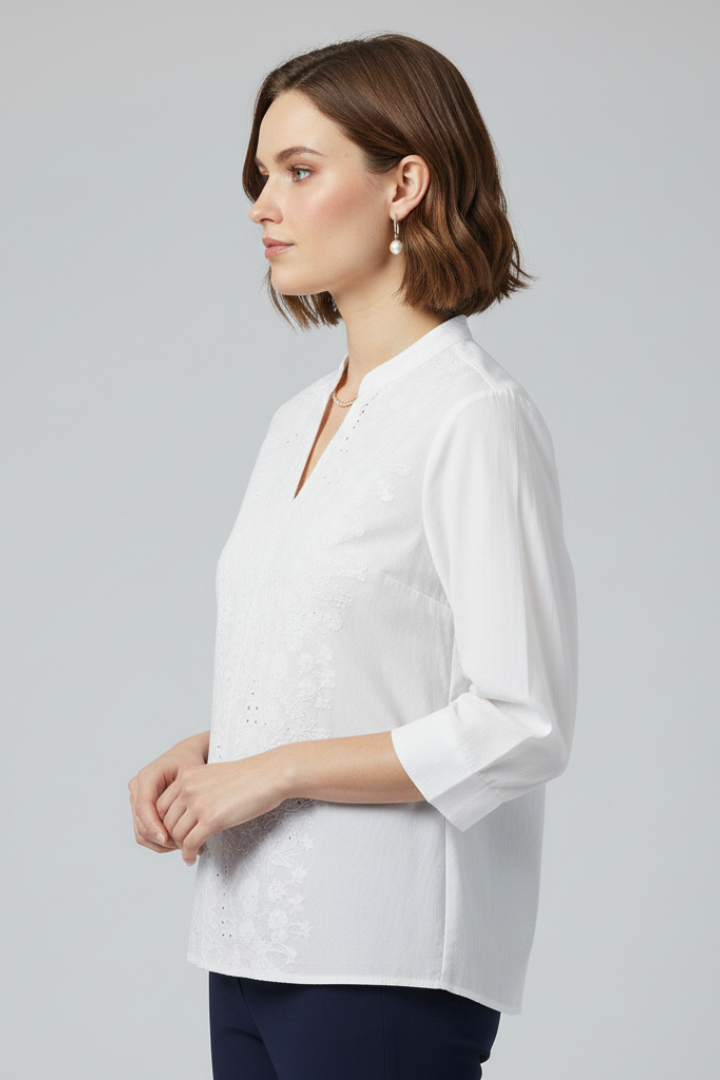 Model with drop earrings wearing white button front blouse with three quarter sleeves