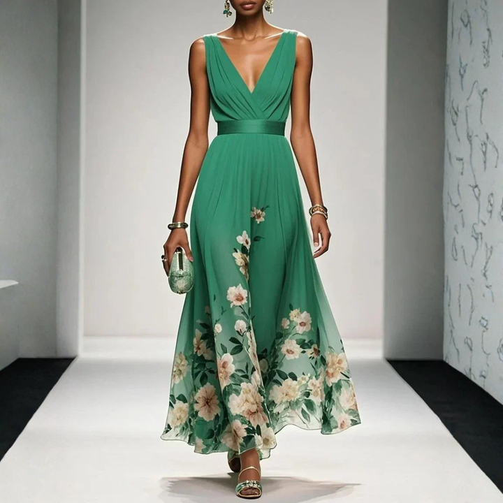 Model posing in a long floral print evening dress on a plain background.