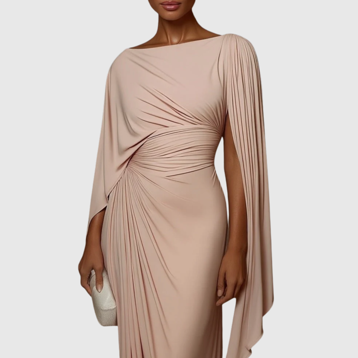 Female wearing a draped maxi dress with pleated detailing against a plain background.