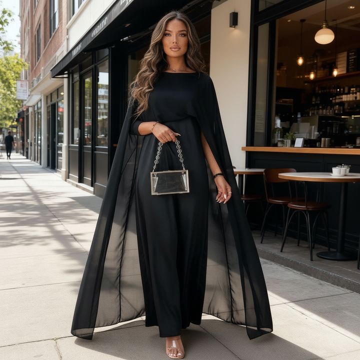 Model showcasing a floor-length formal dress with draped cape detail on a plain background.