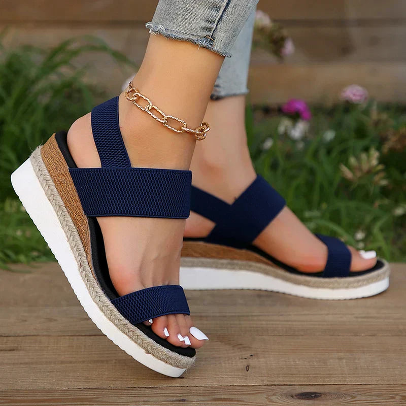 Foot model showing sandal fit from front on brown floor.