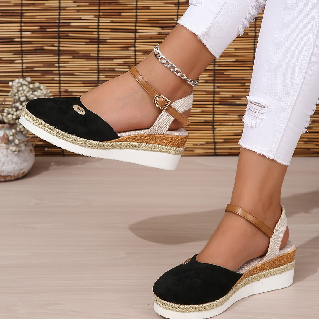 Foot angled inward wearing sandals on gray floor background